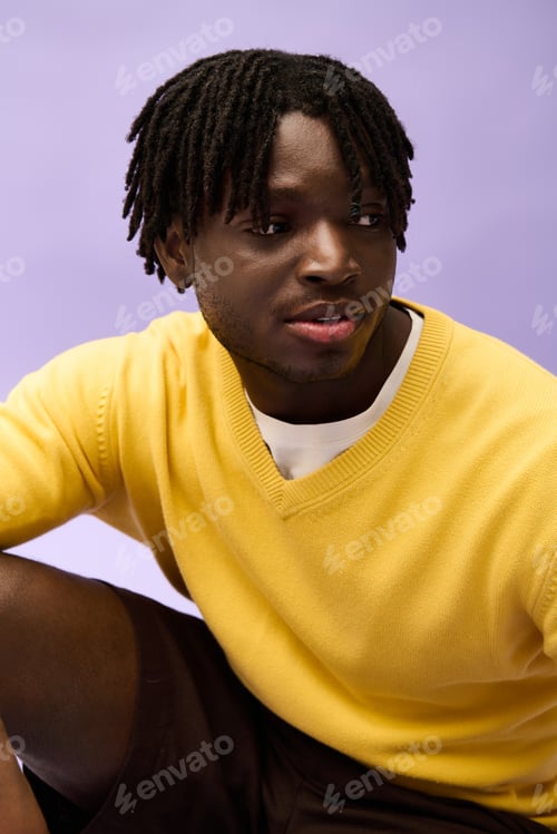 Preview: Handsome young man showcasing stylish attire against a creative backdrop