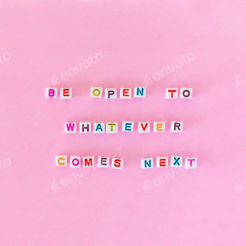 Preview: Quote “Be open to whatever comes next” made out of beads on pink background, top view