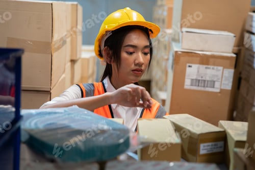 Preview: woman wearing visible vest hold clipboard in warehouse check and arrange box in the steel shelf