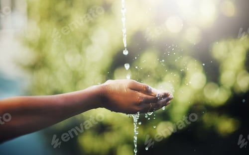 Preview: Water is key to life. Cropped shot of hands held out to catch a stream of water outside.