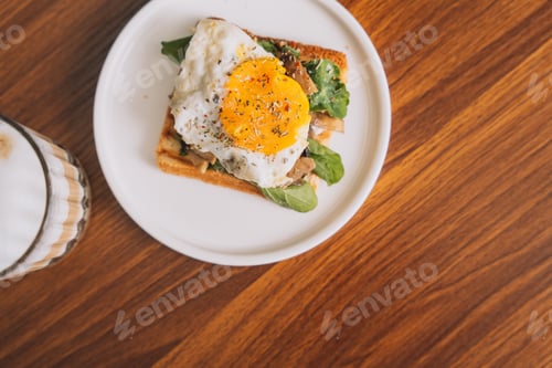 Preview: Toast with scrambled eggs and lettuce on a white plate with coffee