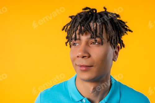 Preview: Friendly young man on yellow studio background. Copy space. Teenager student guy