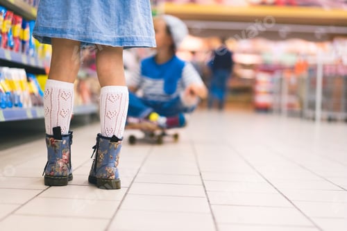 Preview: cropped view of female kid standing in supermarket