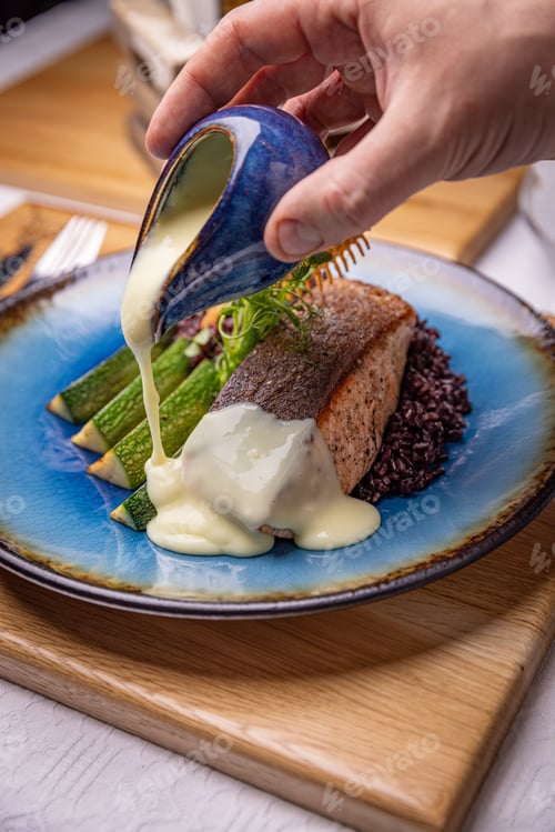Preview: Chef pouring sauce on salmon steak
