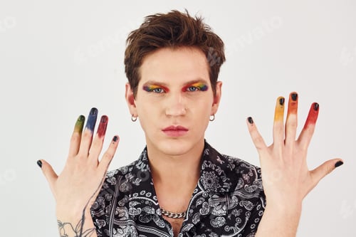 Preview: Young gay man is standing in the studio and posing for a camera