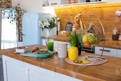 Preview: Green apple, pear and orange mandarin are in a metal hanging vase in the kitchen