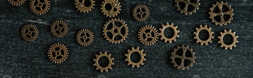 Preview: top view of vintage metal gears on dark wooden background, panoramic shot