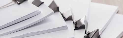 Preview: panoramic shot of stacks of blank paper with metal binder clips