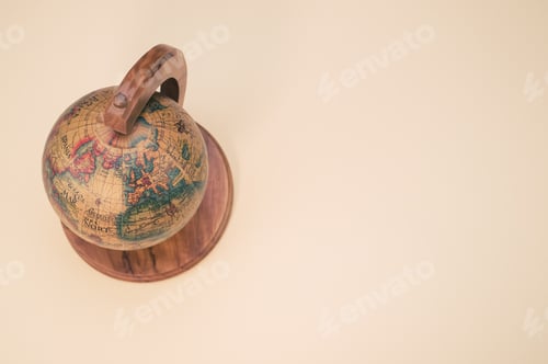 Preview: Closeup shot of a small wooden globe isolated on a pink background with copy spac