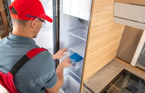 Preview: Technician Organizing Fresh Produce in Refrigerator During RV Service Call