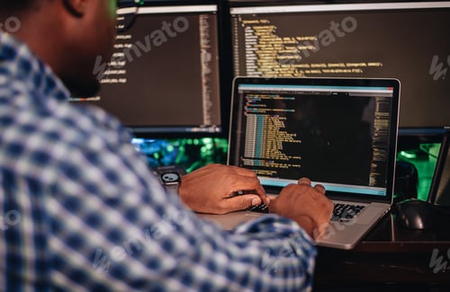 Preview: A black man sitting at a computer coding away, computer programming, diversity in STEM