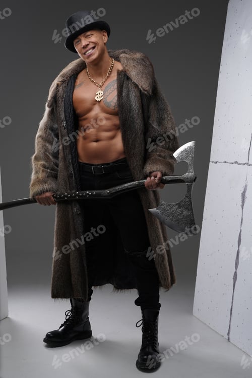Preview: Bodybuilder with naked torso and hat holding huge axe