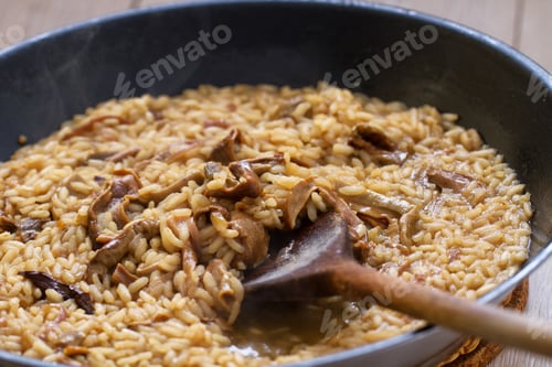 Preview: Cooking Mushroom Risotto with Wooden Spoon.