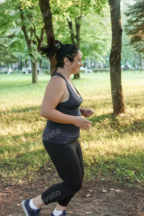 Preview: A charming brunette woman plus-size body positive practices sports in nature.