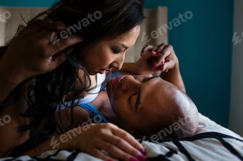 Preview: Mid adult couple kissing on bed