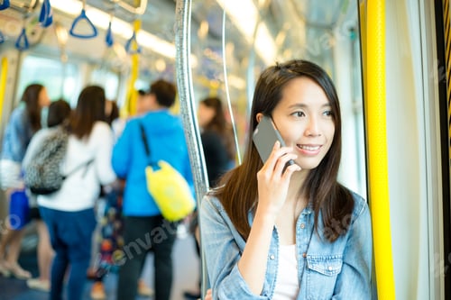Preview: Woman talk to mobile phone in train compartment at hong Kong