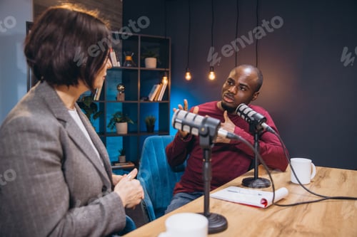 Preview: Two diverse podcasters engaging in a discussion while recording their show in a professional studio