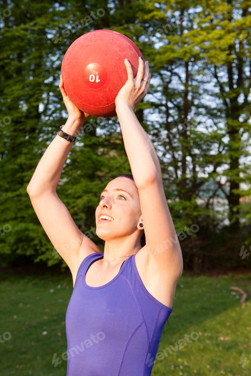 Preview: Young beautiful woman holding ball in park