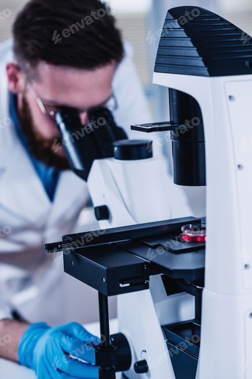 Preview: Young Male Researcher Looking At Samples Under Microscope