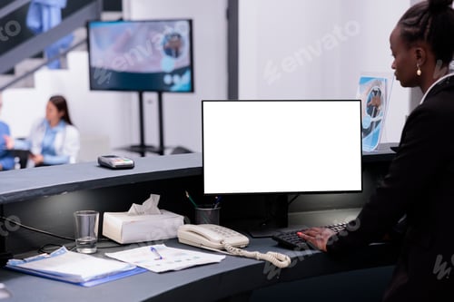 Preview: African american receptionist using white isolated screen on computer while working at hospital