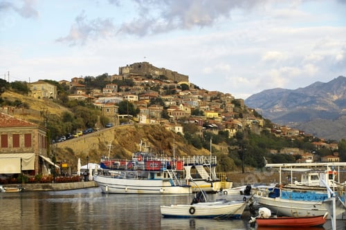Preview: Castle on the hill above Greek town Molyvos on vacation island Lesvos. Harbour boats in foreground.