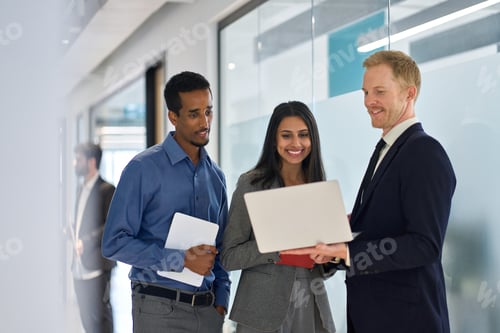 Preview: Happy professional diverse team people standing in office looking at laptop.