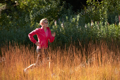 Preview: Jogger running on grassy field