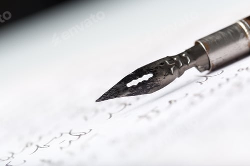 Preview: Writing on parchment paper with vintage calligraphy dip pen during the day