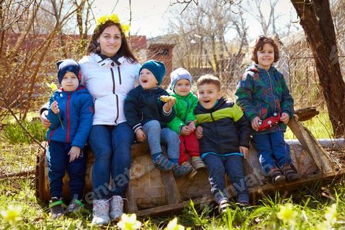 Preview: young mother and her children and nephews outside on a sunny day