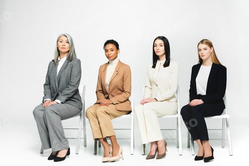 Preview: Four Women Sitting in a Row Wearing Suits