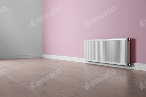 Preview: Modern radiator on color wall indoors. Central heating system