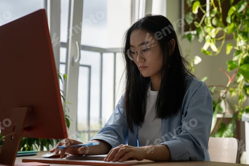 Preview: Young Asian woman freelance journalist using computer, writing for magazines and newspapers