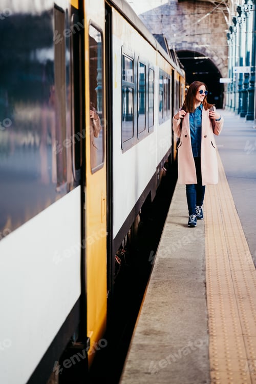 Preview: happy young woman walking at train station. Travel concept