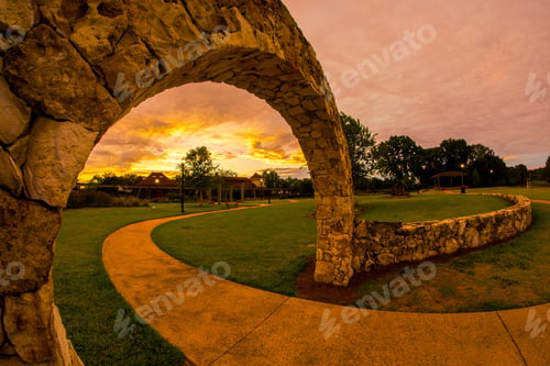 Preview: Park landscape with stone archway and sunset sky.