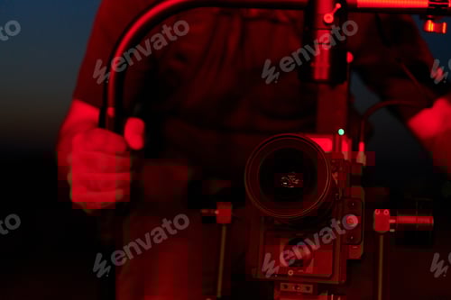 Preview: Nighttime Capture: Professional Videographer Films Athletes Running in Red-Lit Darkness