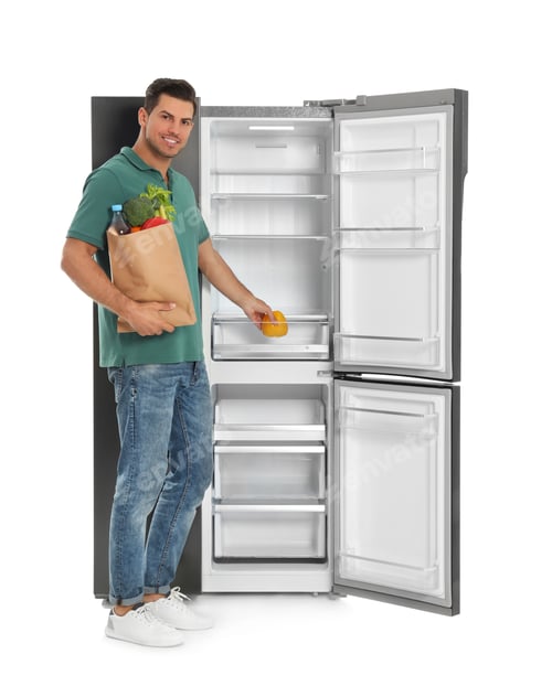 Preview: Man with bag of groceries near open empty refrigerator on white background