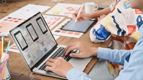 Preview: Cropped image of two people is using a computer laptop with an interface icon.