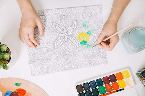 Preview: Young woman is coloring page anti stress book, mental wellbeing concept.