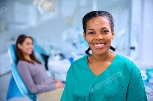 Preview: Happy black stomatologist working at dentist's office and looking at camera.