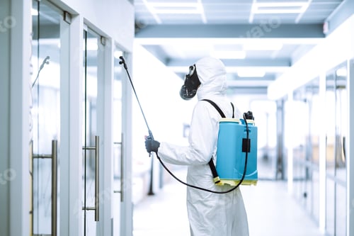 Preview: Disinfecting of office to prevent COVID-19, Man in protective hazmat suit with spray chemicals.