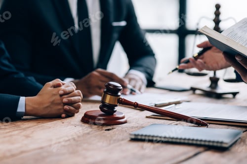 Preview: Close-up of a judge with a hammer against the background of professional lawyer talking about