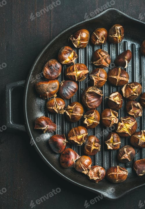 Preview: Roasted chestnuts in grilling pan over dark wooden background
