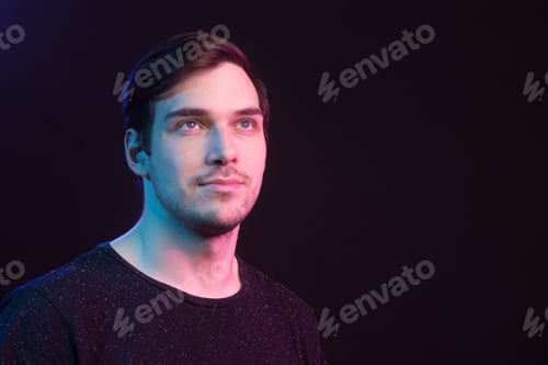 Preview: Young Male Looking Up, Colored Gel Lights. Studio Shot, Black Background.