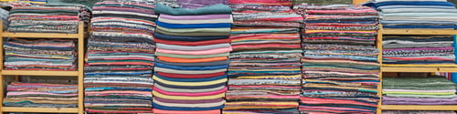 Preview: Stacks of colorful striped and monochromatic home handmade rugs