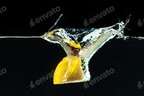 Preview: fresh yellow lemon in water splash on black background