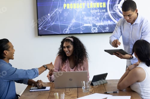 Preview: Diverse business team collaborating on product launch presentation in modern office