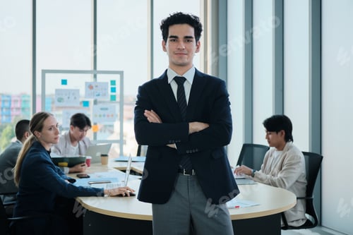 Preview: Confident male Hispanic CEO standing and looking at camera in meeting.