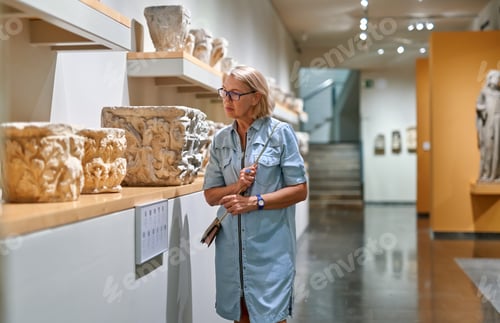 Preview: Woman Visitor In Historical Museum Looking At Art Object