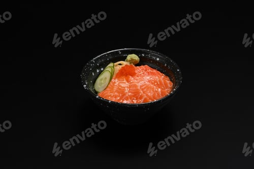 Preview: Bowl of salmon Donburi served with wasabi and prickled ginger on black background.
