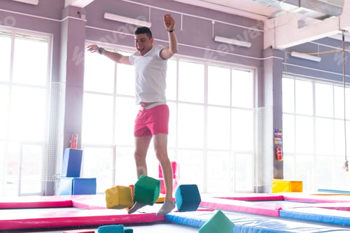 Preview: Fitness, fun, leisure and sport activity concept - Handsome happy man jumping on a trampoline